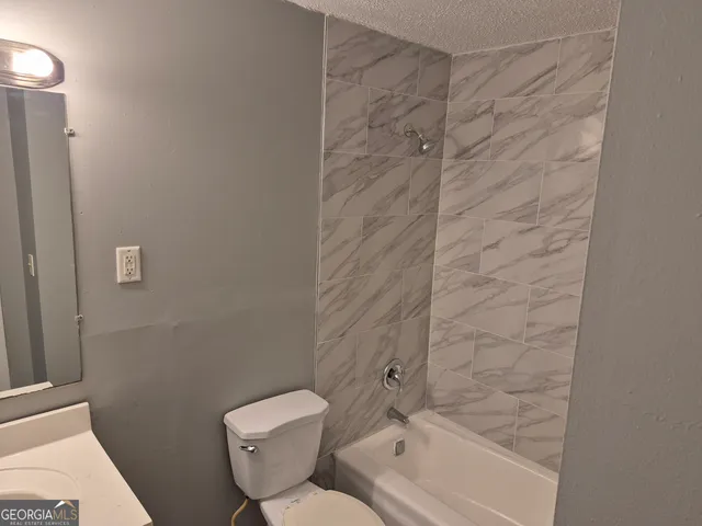 a white toilet sitting next to a sink