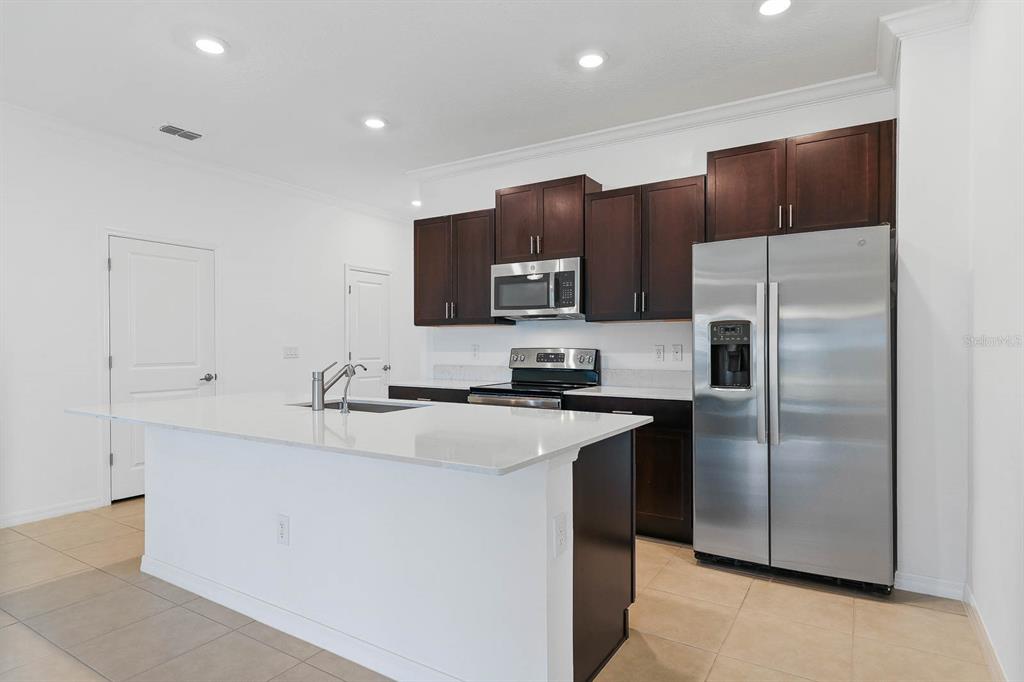 13755 Big Hawk Way Lithia, FL 33547 - Photo 11 of 33 a kitchen with kitchen island a sink stainless steel appliances and cabinets