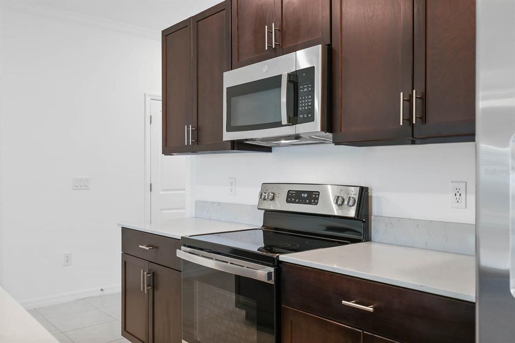 13755 Big Hawk Way Lithia, FL 33547 - Photo 10 of 33 a kitchen with a stove and a microwave