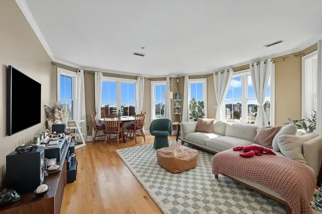 a living room with furniture flat screen tv and large window