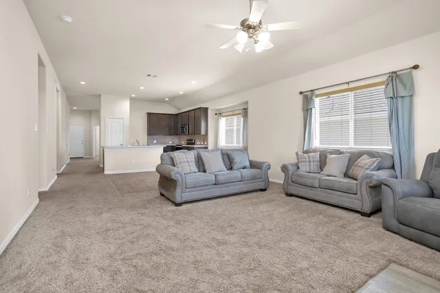 a kitchen with stainless steel appliances granite countertop a stove top oven a sink and a refrigerator