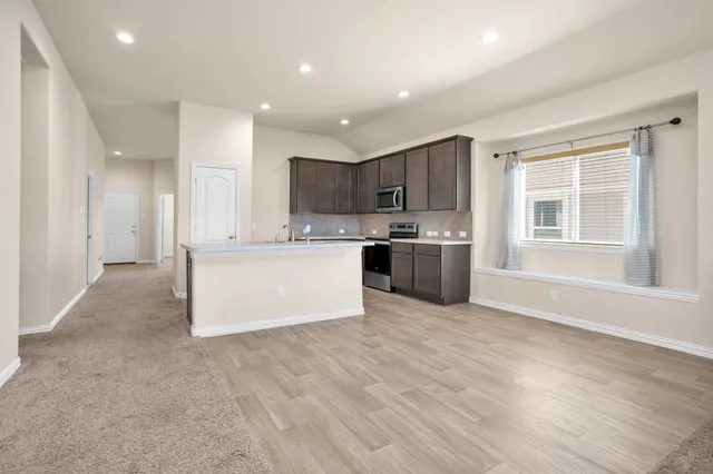a kitchen with sink a microwave a stove and cabinets
