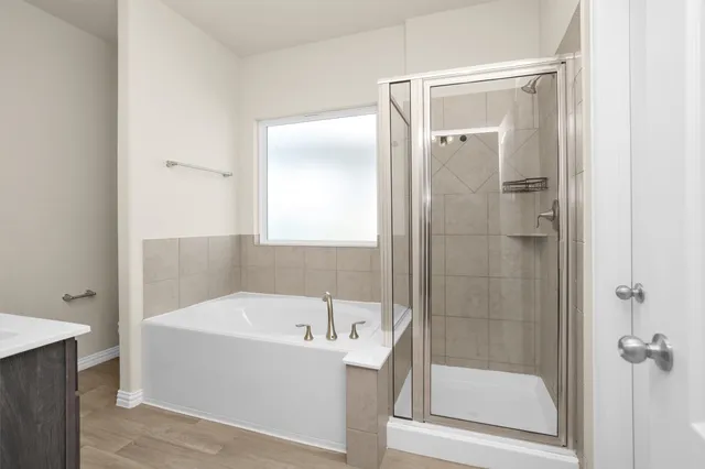 a bathroom with a tub a sink and a mirror