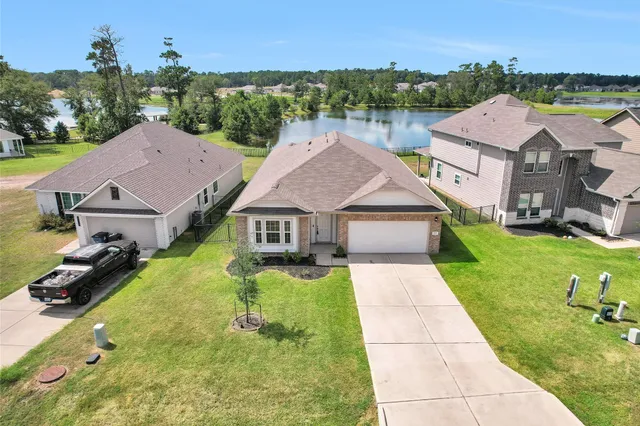 an aerial view of residential houses with outdoor space and parking