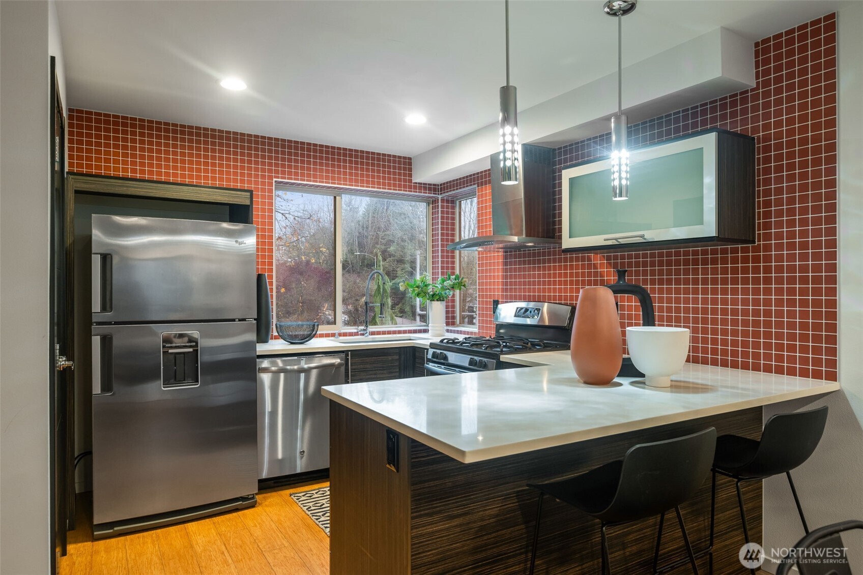 7758 Delridge Way Southwest Seattle, WA 98106 - Photo 7 of 22 a kitchen with stainless steel appliances granite countertop a sink a microwave cabinets and wooden floor