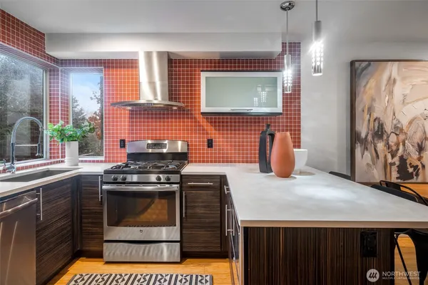 a kitchen with stainless steel appliances granite countertop a stove a sink and a microwave