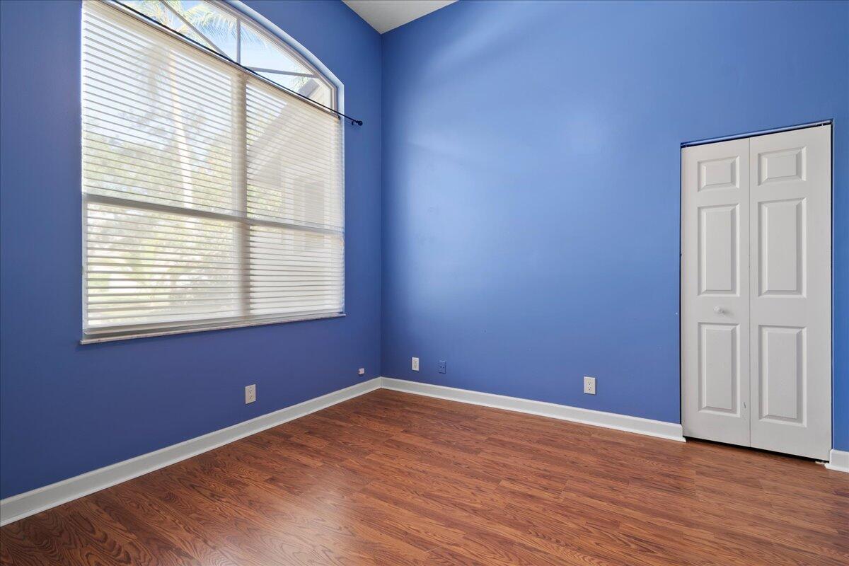 6989 Cypress Cove Circle Jupiter, FL 33458 - Photo 24 of 47 an empty room with wooden floor and windows
