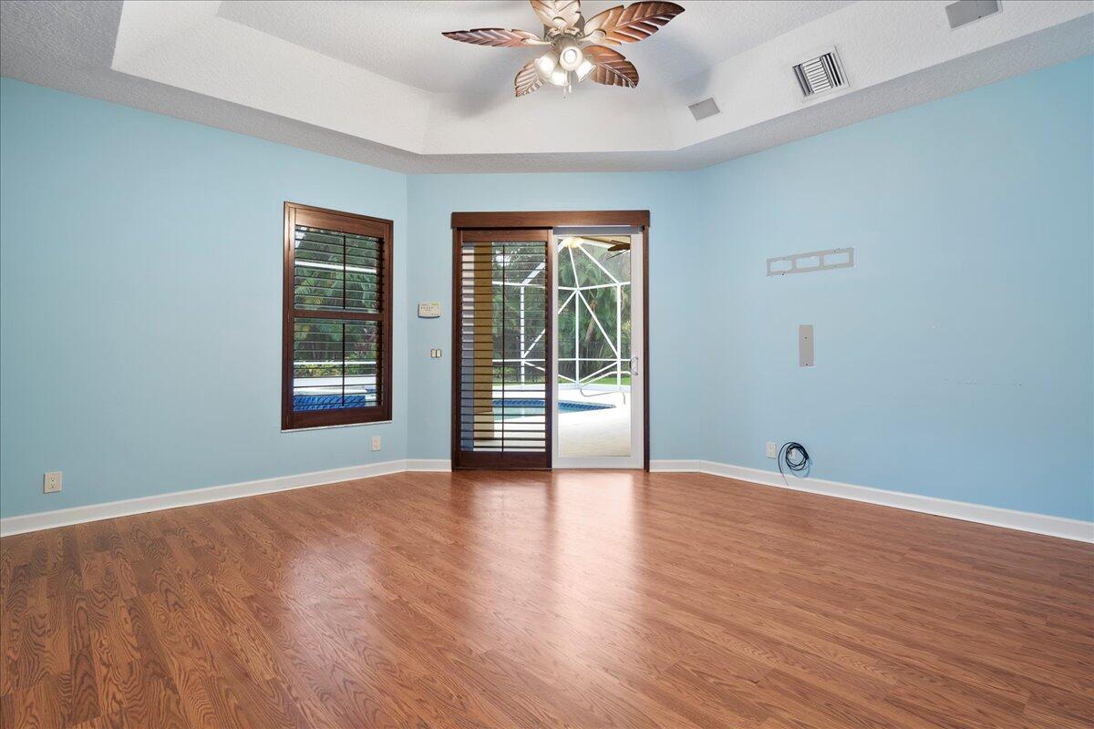 6989 Cypress Cove Circle Jupiter, FL 33458 - Photo 26 of 47 a view of an empty room with wooden floor and a window