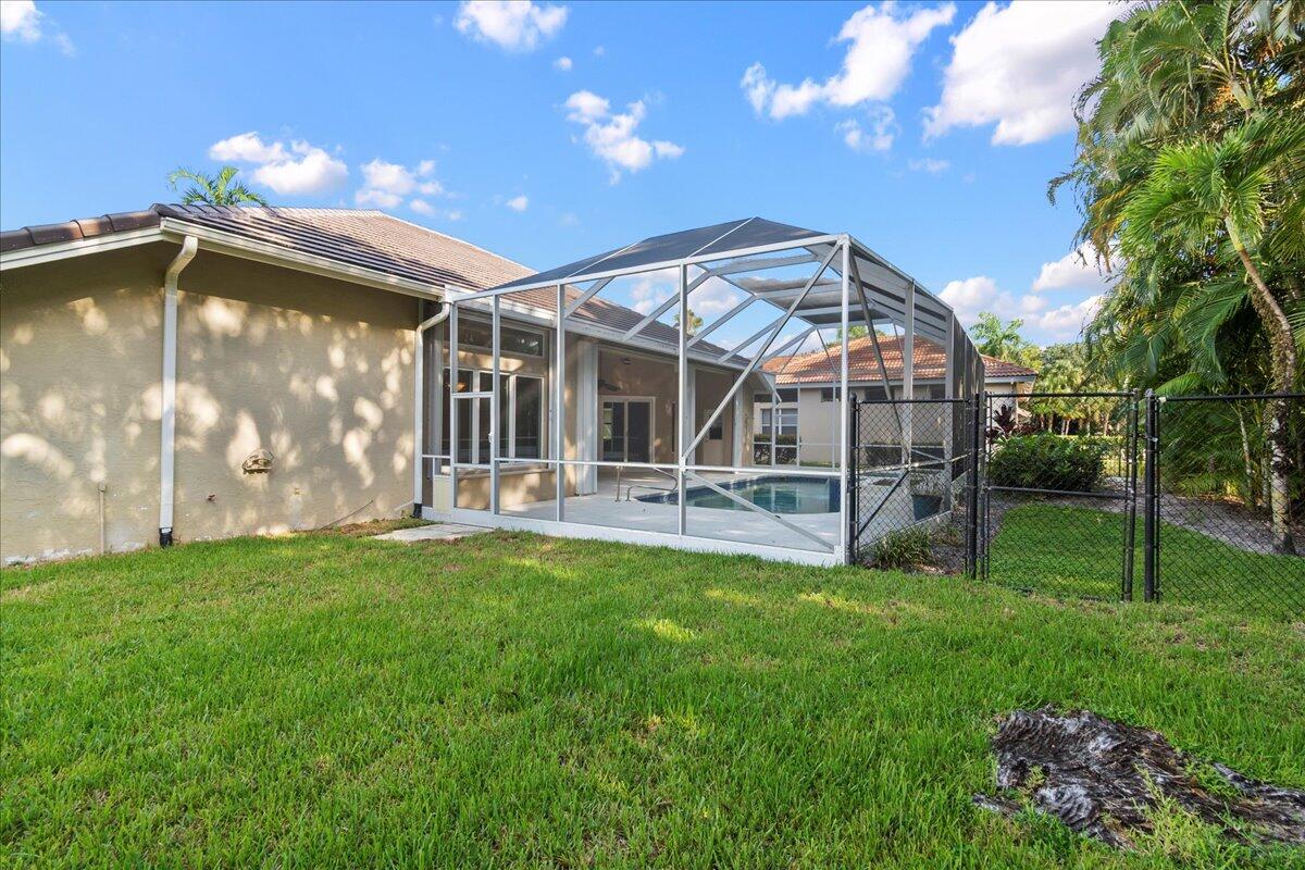 6989 Cypress Cove Circle Jupiter, FL 33458 - Photo 3 of 47 a view of a backyard with table and chairs and wooden fence