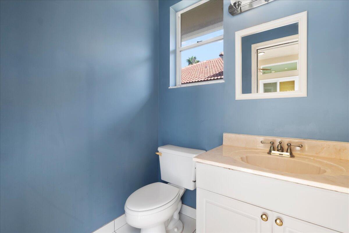 6989 Cypress Cove Circle Jupiter, FL 33458 - Photo 36 of 47 a bathroom with a sink mirror and toilet
