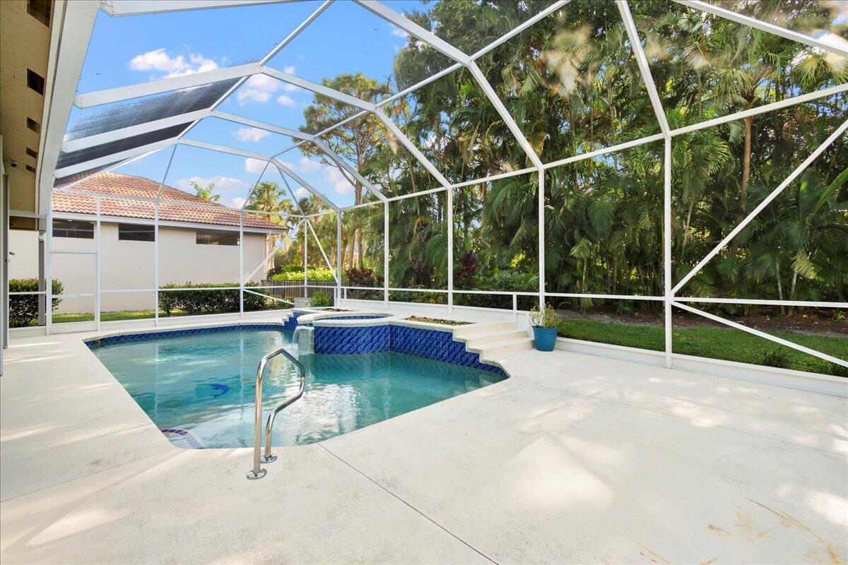 6989 Cypress Cove Circle Jupiter, FL 33458 - Photo 4 of 47 a view of a swimming pool with a lounge chairs