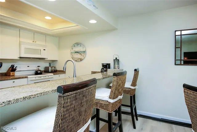 a kitchen with a table chairs sink and cabinets