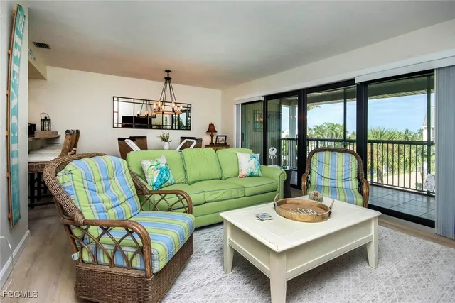 a living room with furniture a flat screen tv and a floor to ceiling window