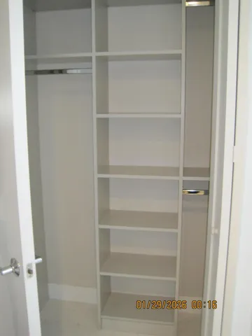 a view of walk in closet with empty racks