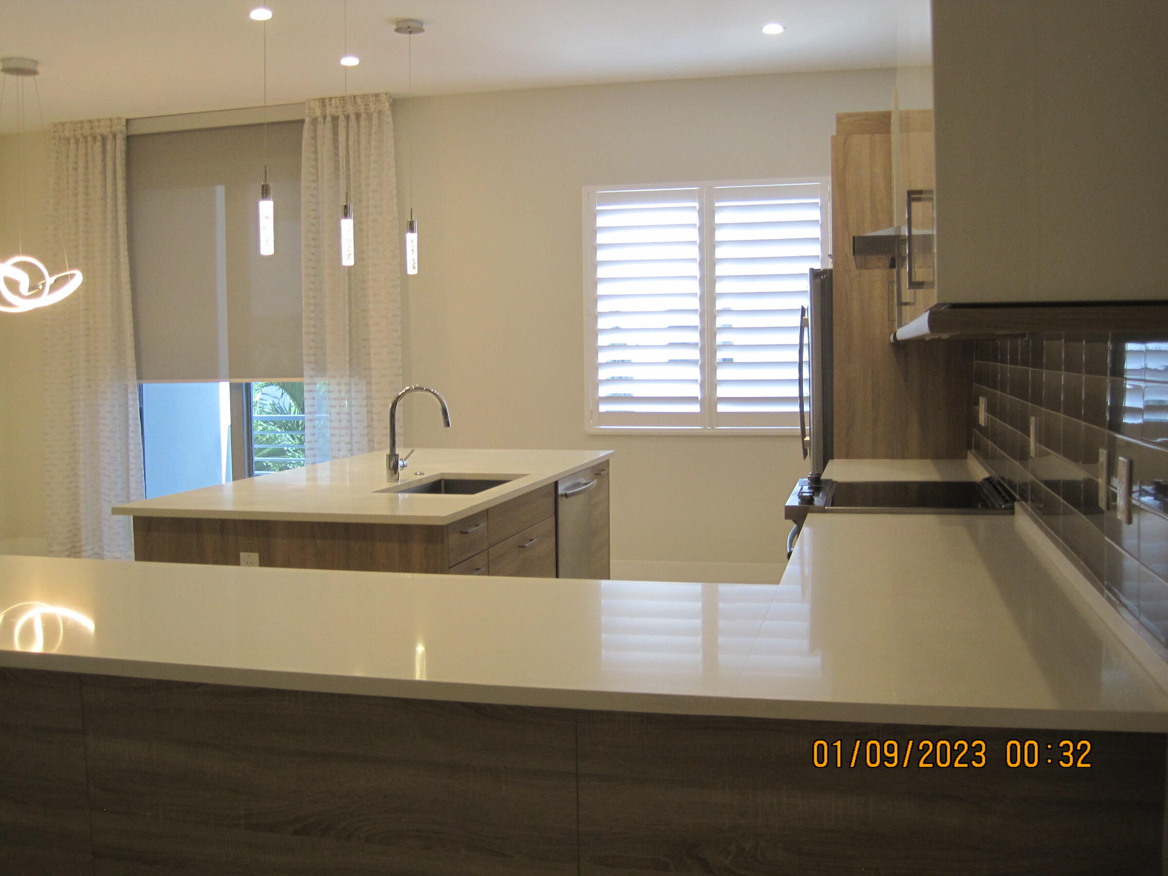 4033 Northwest 17th Way Boca Raton, FL 33431 - Photo 4 of 17 a view of a kitchen with kitchen island a sink wooden floor and glass door