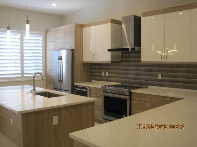 a kitchen with stainless steel appliances granite countertop a sink and a refrigerator