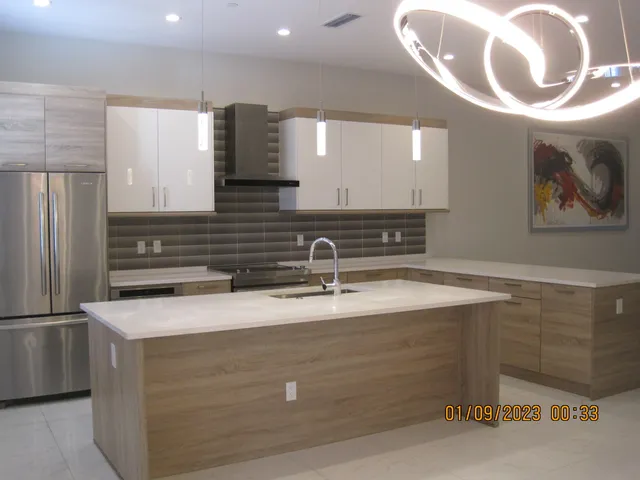a view of a kitchen with a sink and a refrigerator