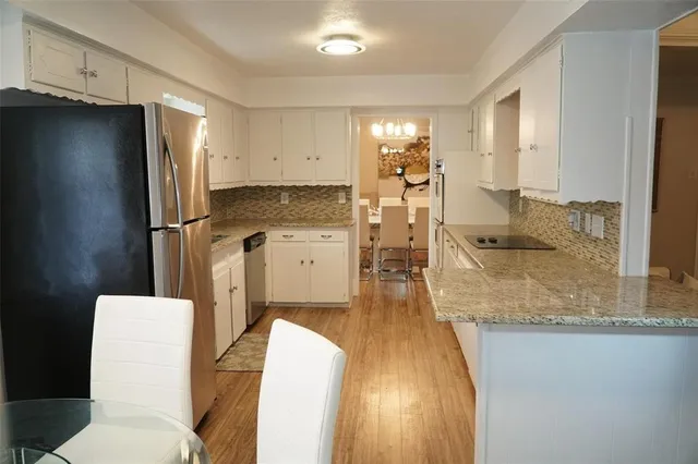 a kitchen with stainless steel appliances granite countertop a refrigerator and a stove