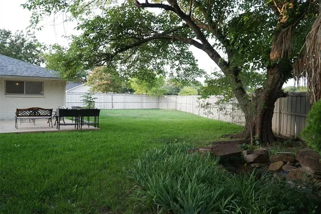 a backyard of a house with table and chairs