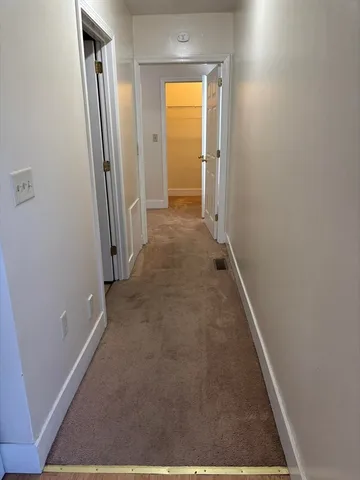 an entryway door with a hallway in the house