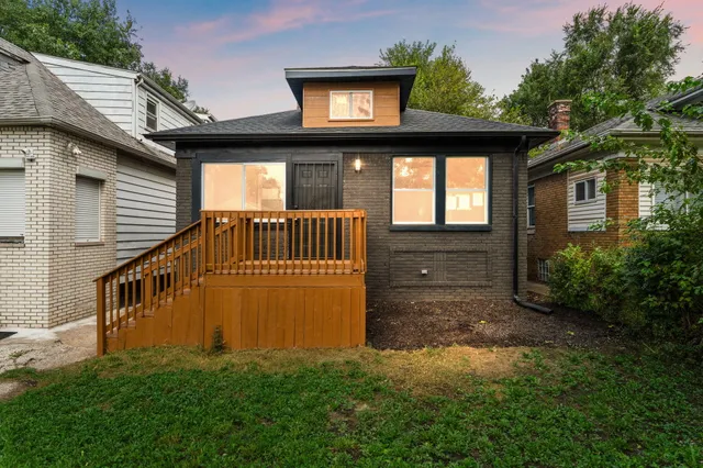 a view of a house with brick walls and a yard with plants
