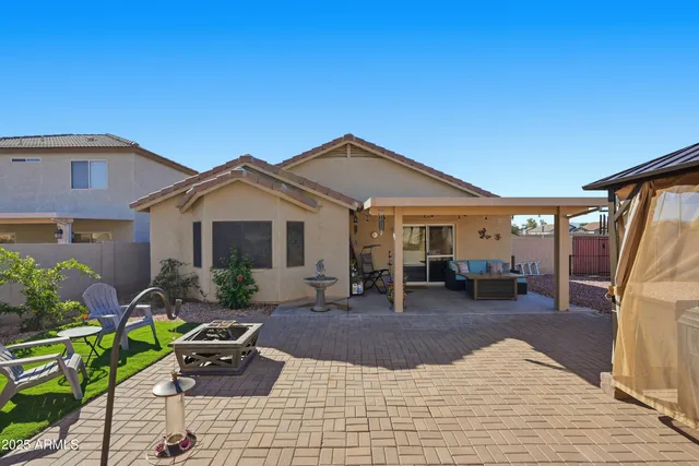 a patio with a table and chairs under an umbrella