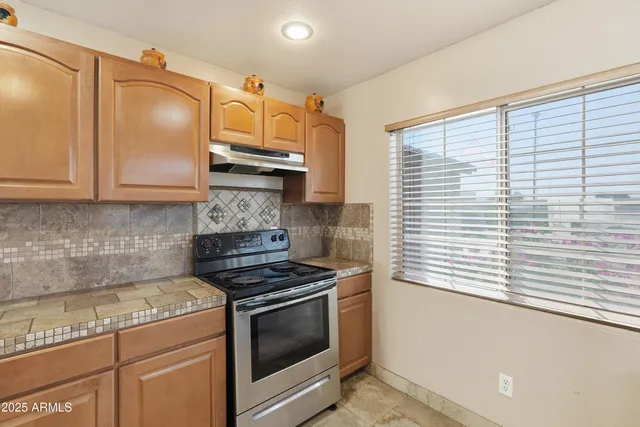 a view of a dining room with furniture a kitchen and chandelier