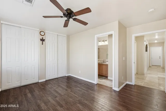 a view of a livingroom with wooden floor and a ceiling fan