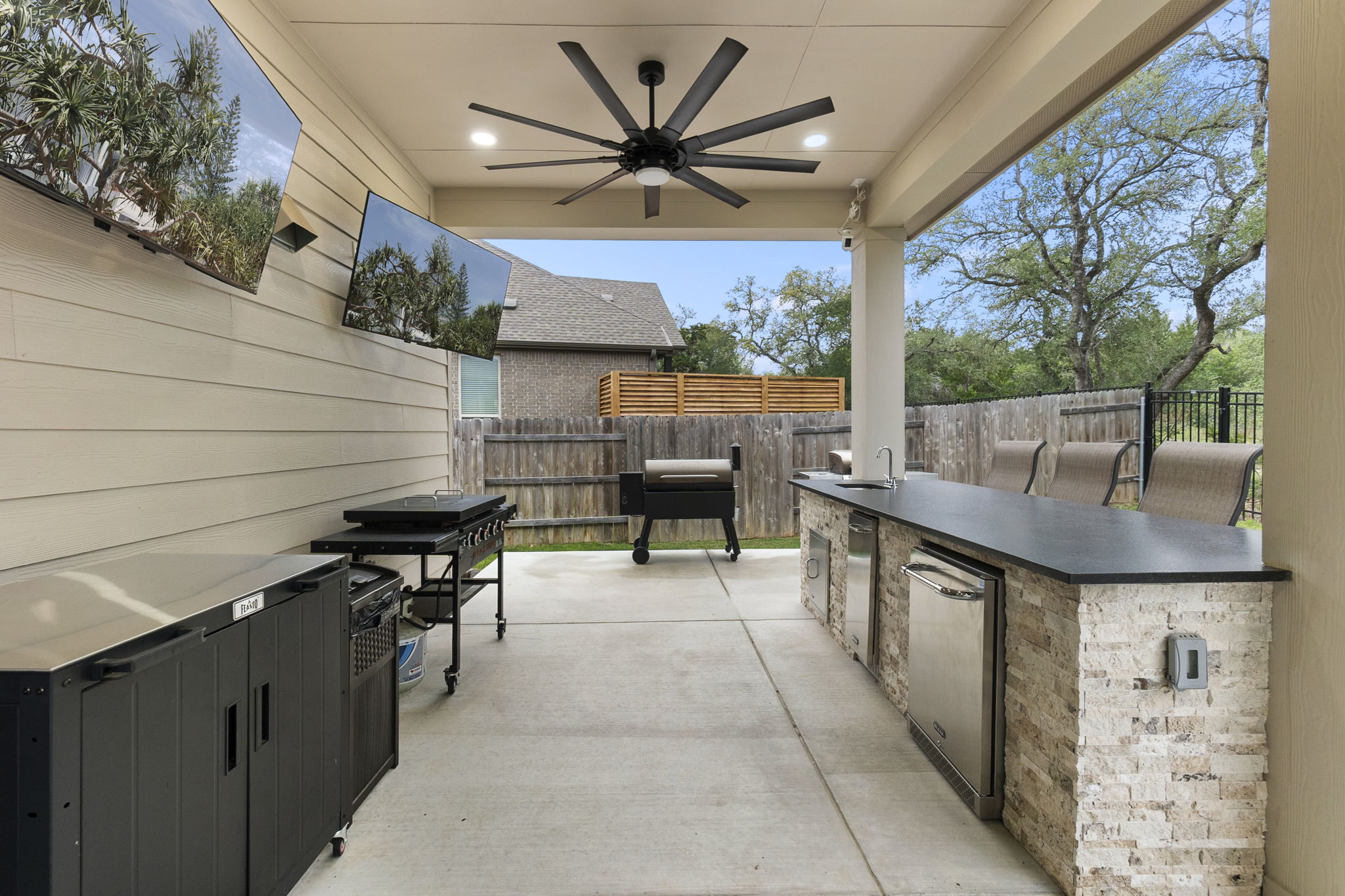 460 Constitution Way Kyle, TX 78640 - Photo 33 of 40 Covered outdoor living space featuring dual wall-mounted televisions and a ceiling fan