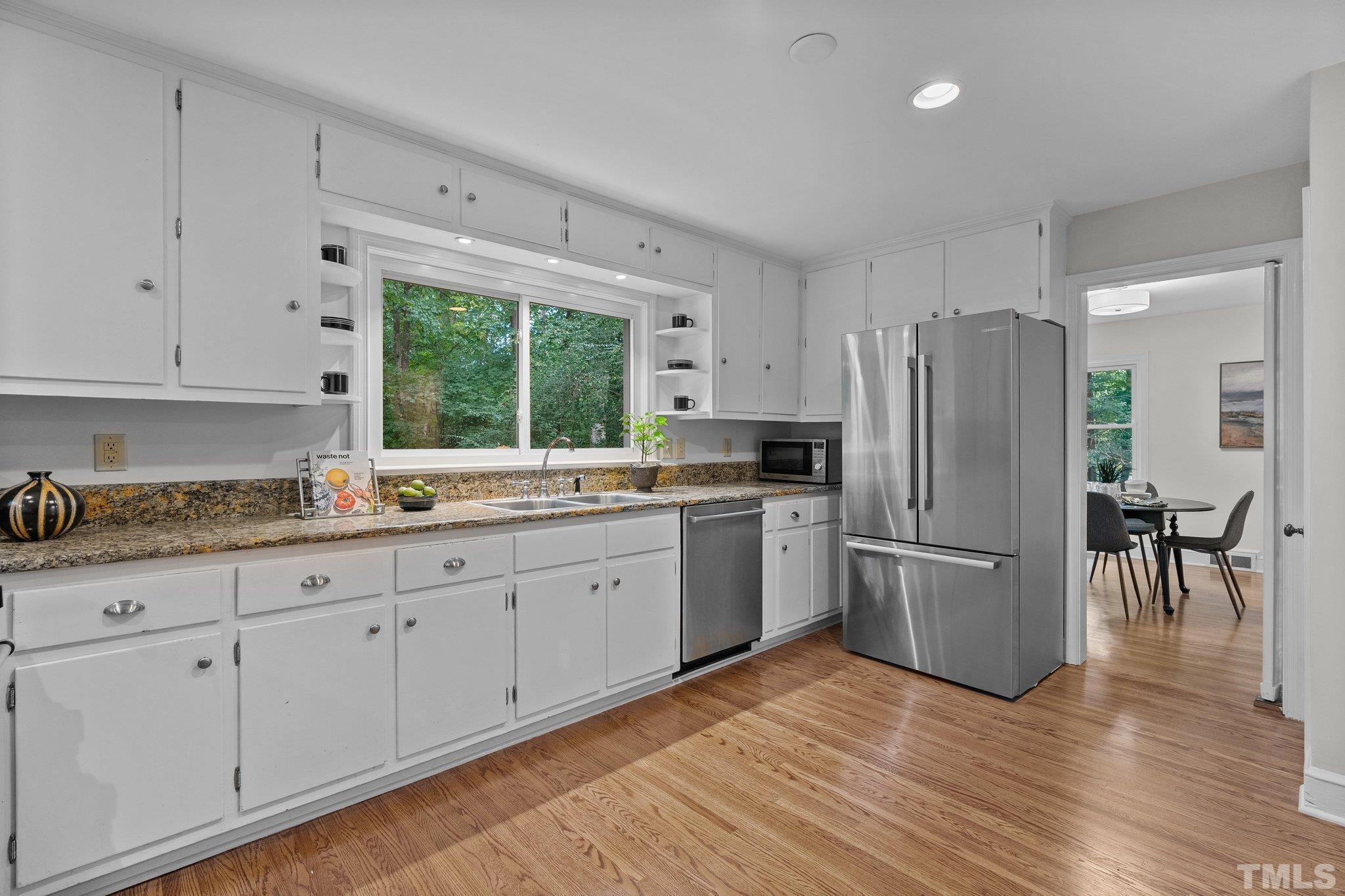 386 St Marys Road Hillsborough, NC 27278 - Photo 17 of 64 a kitchen with granite countertop a refrigerator a sink dishwasher a stove and white cabinets with wooden floor