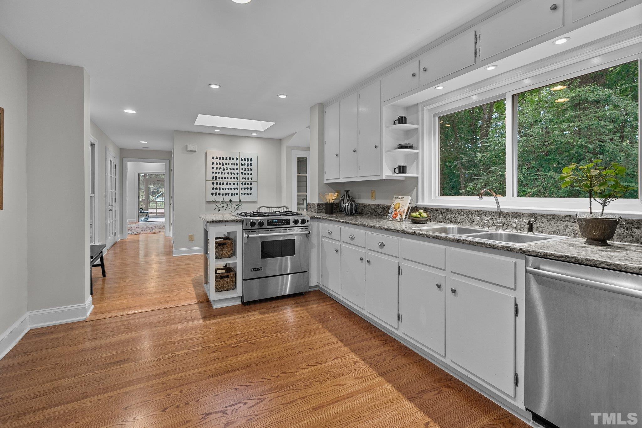 386 St Marys Road Hillsborough, NC 27278 - Photo 18 of 64 a kitchen with stainless steel appliances granite countertop wooden cabinets a sink a stove a chimney wooden floor and a large window