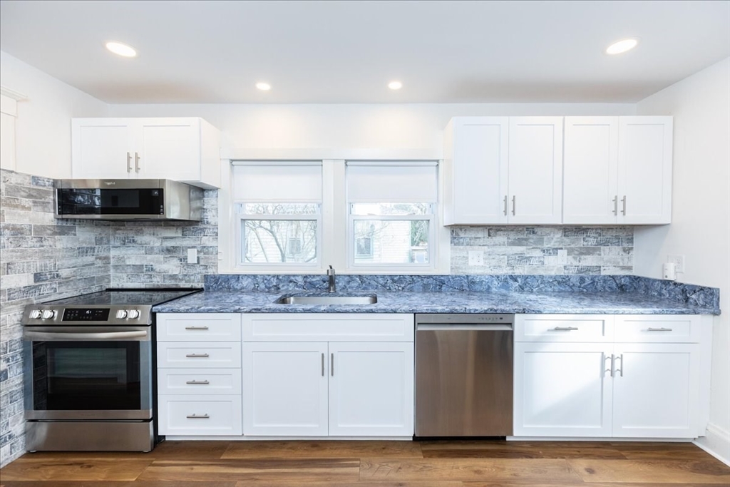 2 Martin Street Marblehead, MA 01945 - Photo 12 of 40 a kitchen with stainless steel appliances granite countertop a stove a sink and white cabinets