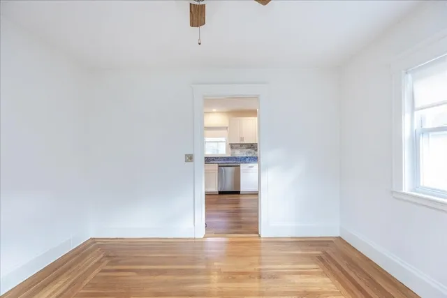 a view of a room with wooden floor and a window