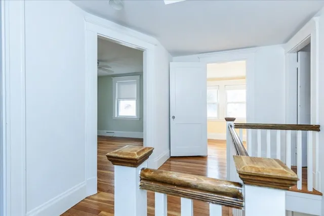 a view of a hallway with wooden floor and staircase