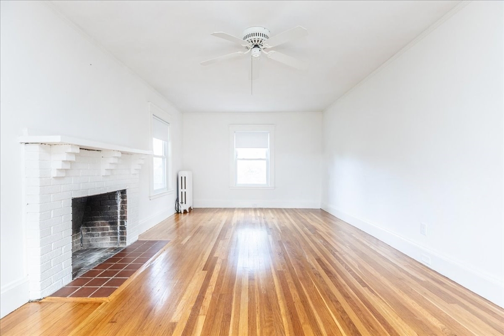 2 Martin Street Marblehead, MA 01945 - Photo 9 of 40 a view of an empty room with wooden floor fireplace and a window
