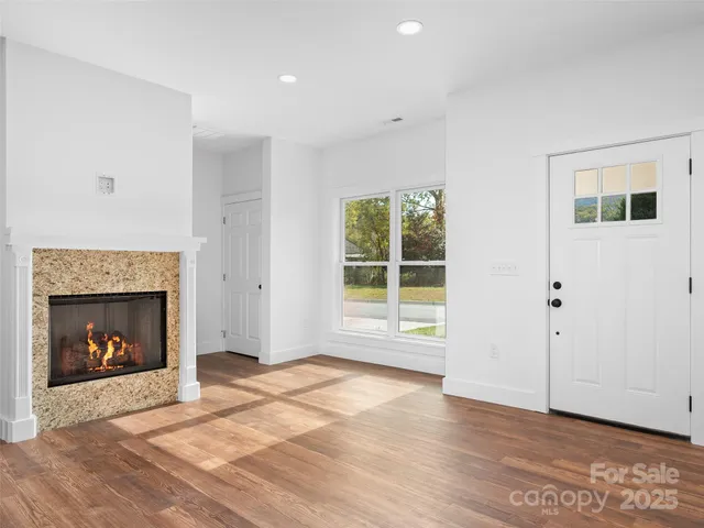 a view of an empty room with a fireplace and window
