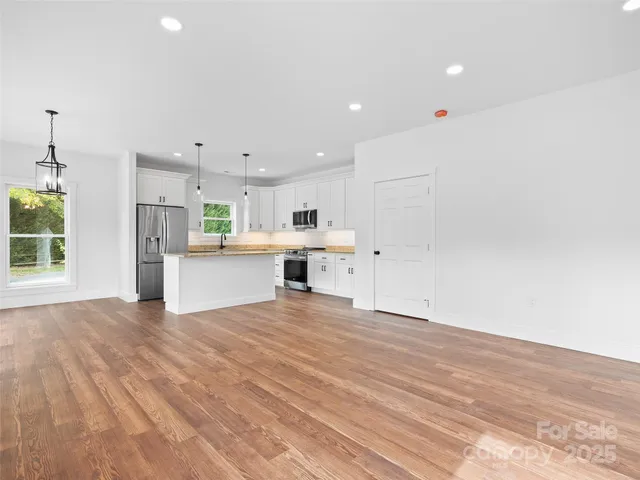 an empty room with kitchen appliances and windows