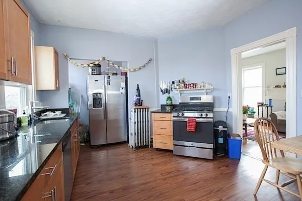 a kitchen with stainless steel appliances a stove cabinets and wooden floor