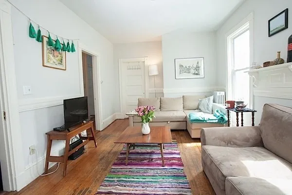 a living room with furniture a rug and a flat screen tv