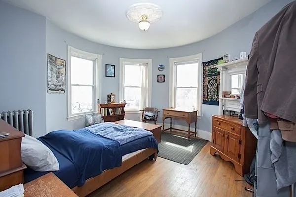 a bedroom with a bed and wooden floor