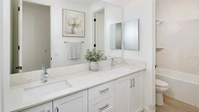 a bathroom with a sink a toilet and a large mirror