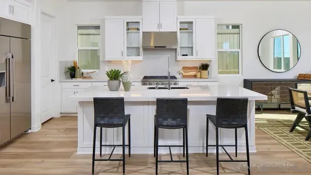 a kitchen with stainless steel appliances granite countertop a stove a sink a dining table and chairs