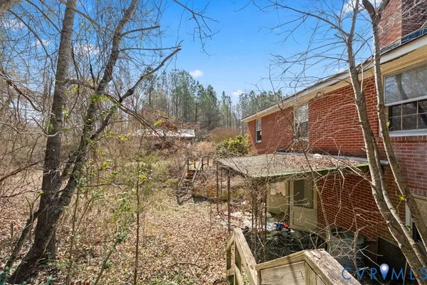 a backyard of a house with table and chairs under an umbrella