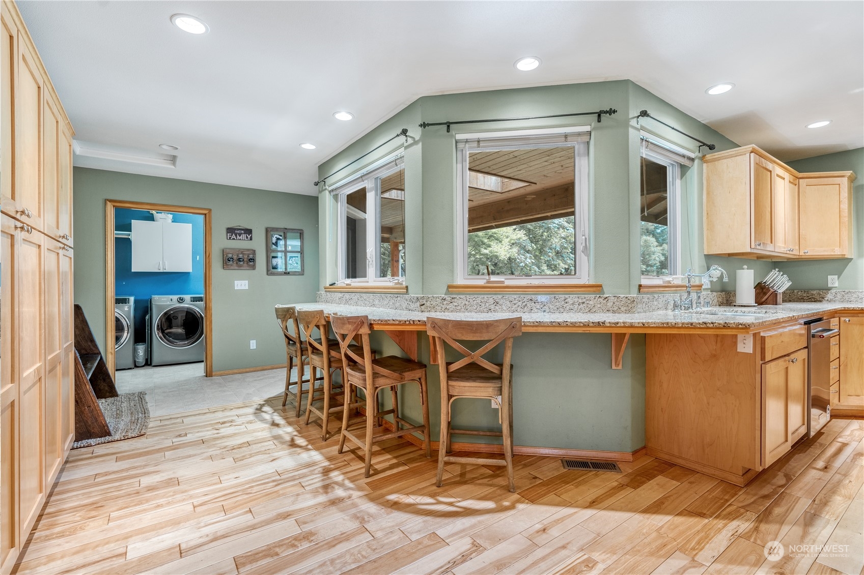 2109 Grove Road Northwest Olympia, WA 98502 - Photo 11 of 40 a dining hall with stainless steel appliances granite countertop a stove top oven a sink dishwasher a dining table and chairs with wooden floor