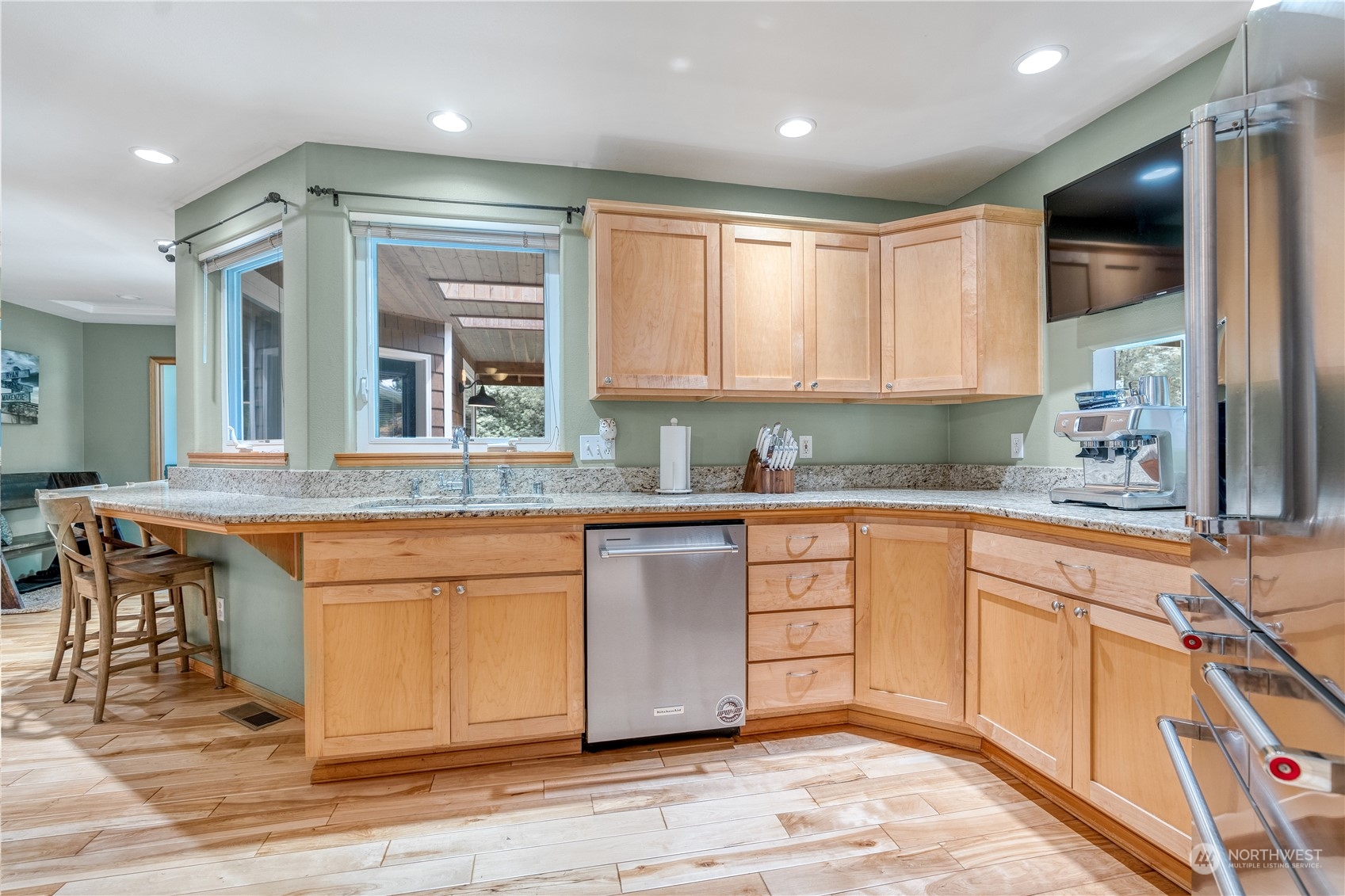 2109 Grove Road Northwest Olympia, WA 98502 - Photo 13 of 40 a kitchen with stainless steel appliances granite countertop a refrigerator a sink dishwasher a stove and white countertops with wooden floor