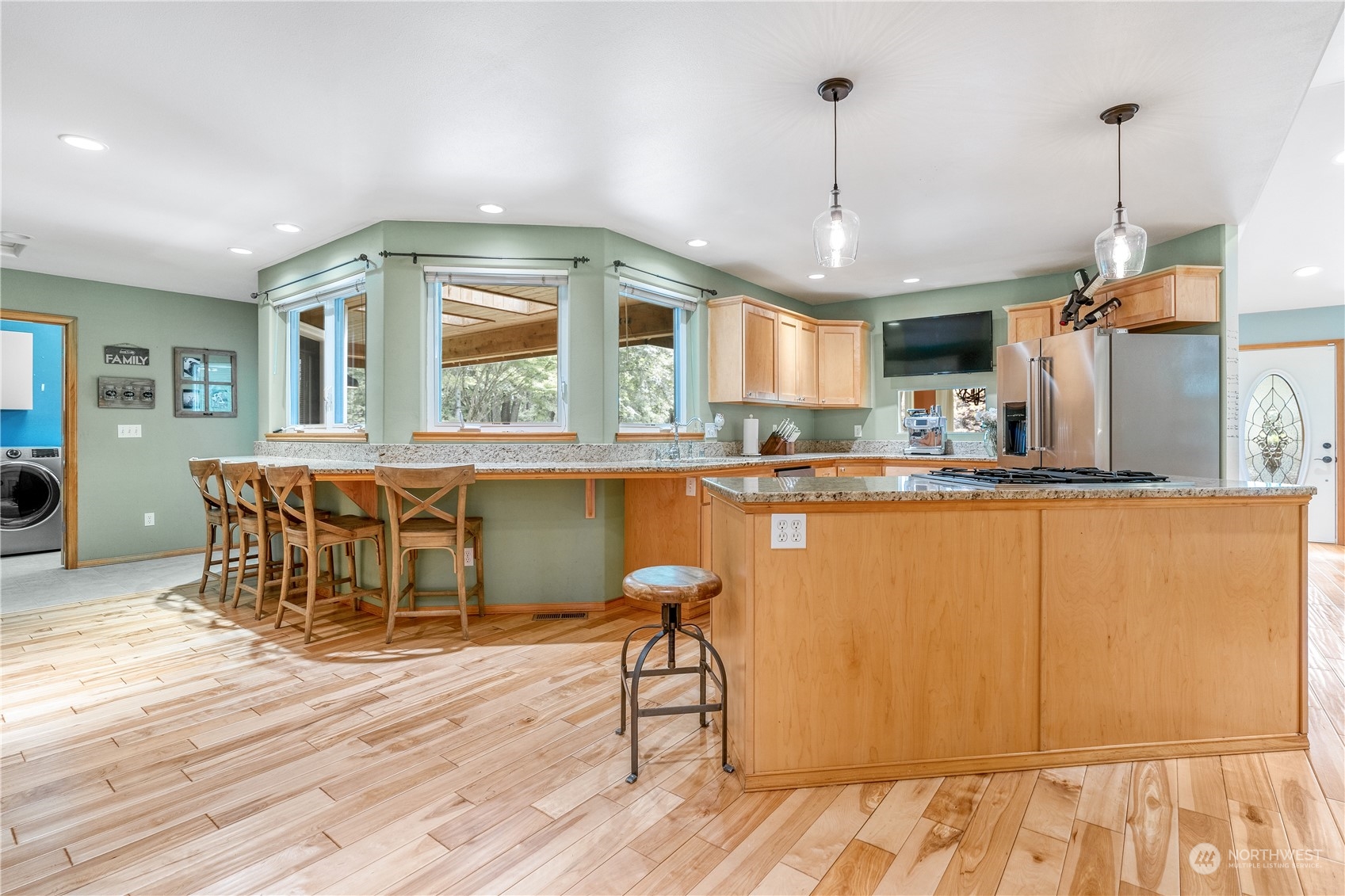 2109 Grove Road Northwest Olympia, WA 98502 - Photo 10 of 40 a kitchen with stainless steel appliances granite countertop a refrigerator a sink dishwasher a stove and a dining table with wooden floor