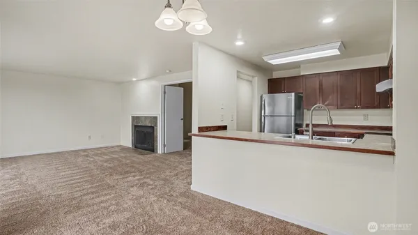 a large kitchen with stainless steel appliances a large counter top a sink and a refrigerator