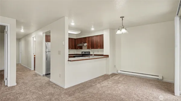 a view of kitchen with refrigerator and white cabinets