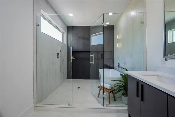 a bathroom with a sink a toilet a shower and a mirror