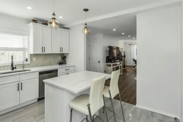 a kitchen with a sink a counter top space appliances and cabinets
